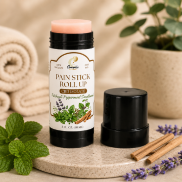 Pain Stick Roll Up CBD isolate with patchouli, peppermint, and sandlewood scents, 2 fl. oz. container with cap removed, placed on a beige surface with towels, mint leaves, cinnamon sticks, and lavender sprigs around
